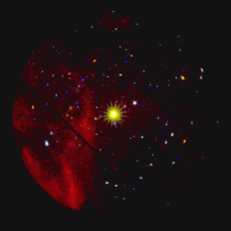 Image du ciel en rayons X prise par l'instrument EPIC (European Photon Imaging Camera) de la mission XMM-NEWTON de l'ESA.<br><i>L'étoile à neutrons 1E1207.4-5209 est la source brillante dans le centre du champ. Les rayons qui l'entourent sont la projection dans le ciel de la structure mécanique du télescope à rayons X. Autour de l'étoile centrale on voit plusieurs dizaines d'objets célestes (au total presque 200) qui, pour la grande majorité, sont observés dans le domaine des rayons X pour la première [...]