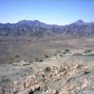 Montagnes constituant l'ophiolite d'Oman. Au premier plan, la croûte océanique fossile est constituée de roches claires. En arrière plan, le manteau fossile forme des reliefs escarpés et sombres.

© Laboratoire de planétologie et géodynamique (CNRS et université de Nantes). Photo Laurent Le Mee.[...]